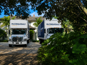 McCorquodale Transfer luxury moving trucks parked at a high-end Palm Beach residence, showcasing white-glove moving, designer delivery, storage, and installation services in South Florida.
